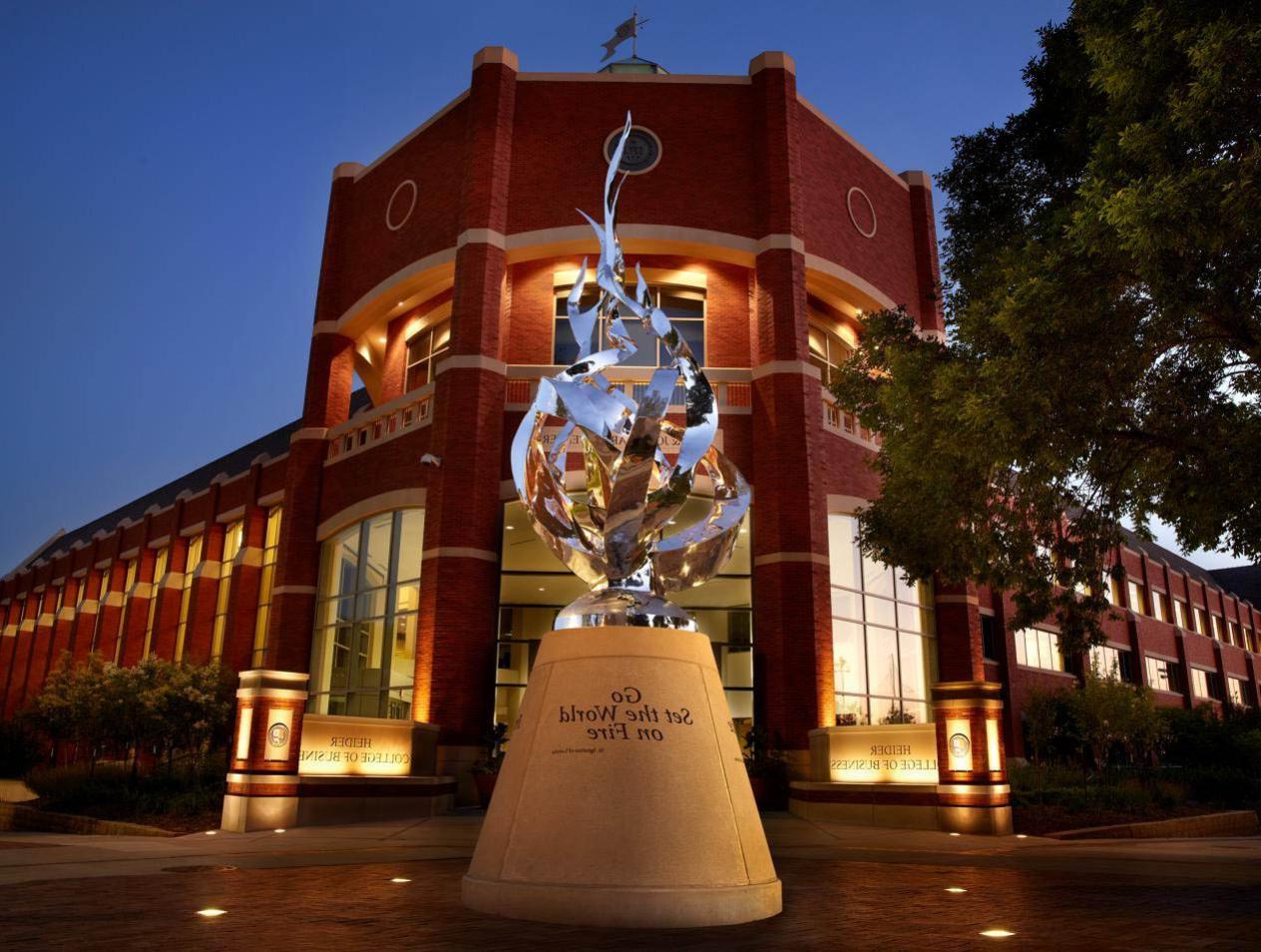 Heider-College-of-Business-flame-statue-at-night