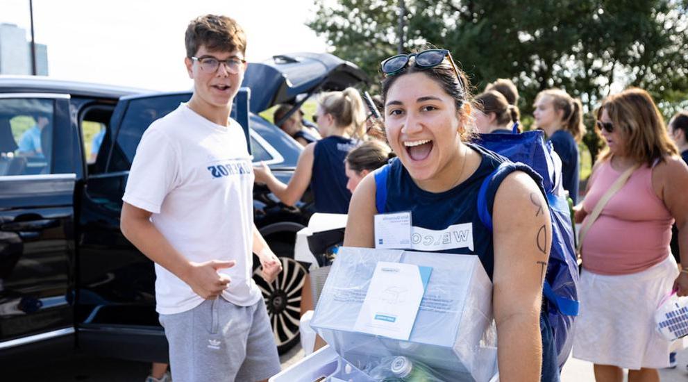 Students carrying boxes into residence halls.